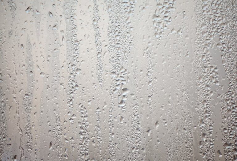 Detailed view of water droplets creating patterns on glass surface.