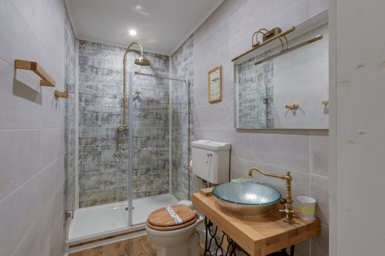 A stylish modern bathroom featuring a glass shower, vessel sink, and wood accents.